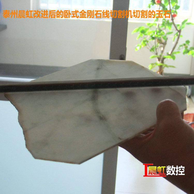 圖為泰州晨虹CHSX5650-XW型數(shù)控金剛石線切割機(jī)切割的玉石